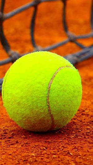 Vibrant Fluorescent Tennis Ball On Court Wallpaper