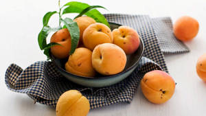 Vibrant Ripe Apricots In A Bowl Wallpaper