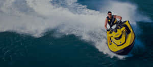 Vibrant Yellow Jet Ski Riding The Waves Wallpaper