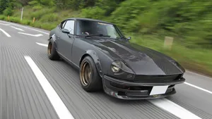Vintage Datsun Car On A Scenic Road Wallpaper