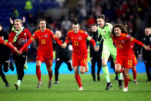 Wales National Football Team Running Across Field Wallpaper