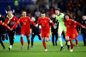 Wales National Football Team Running Across Field Wallpaper