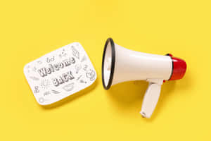 Welcome Back Megaphoneand Signon Yellow Background Wallpaper