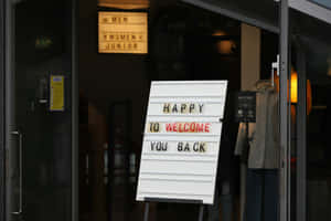 Welcome Back Sign Outside Store Wallpaper