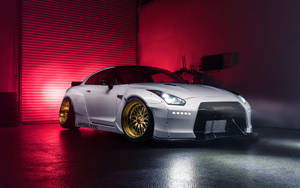 White Nissan Gtr Car With Golden Tires Wallpaper