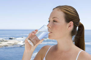 Woman Drinking Water On The Beach Wallpaper