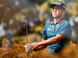 Xander Schauffele Holding A Golf Club Wallpaper