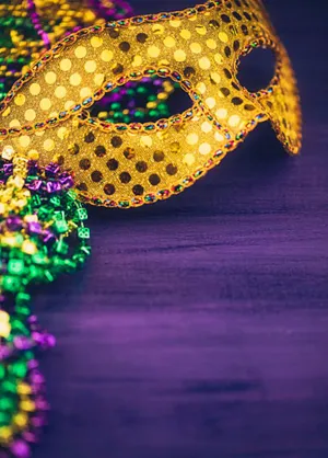 Yellow Mardi Gras Mask On Purple Table Wallpaper