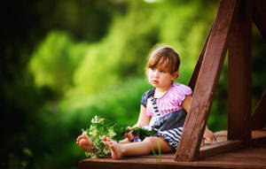 Young Child Holding A Bouquet Of Flowers Wallpaper